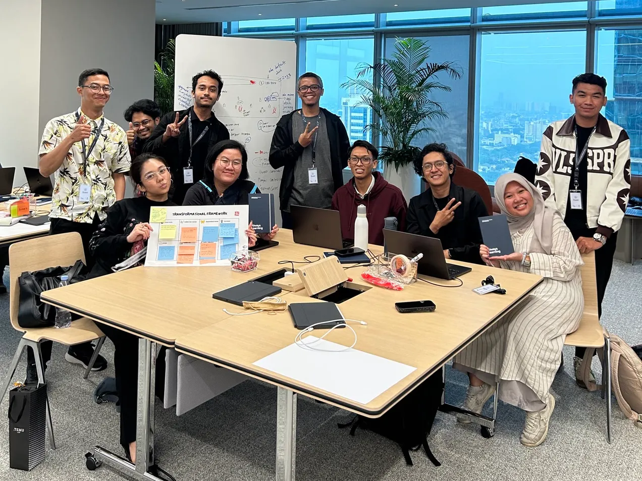 The Asap Jahat team and mentors holding the Transformational Framework poster